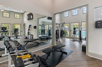 View of the fitness room with cardio equipment and mirrors at The Enclave at Crossroads, Raleigh